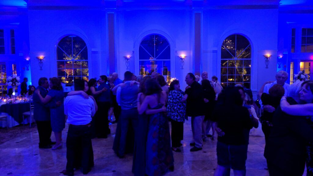 Blue lit dance floor with couples slow dancing at Aria wedding