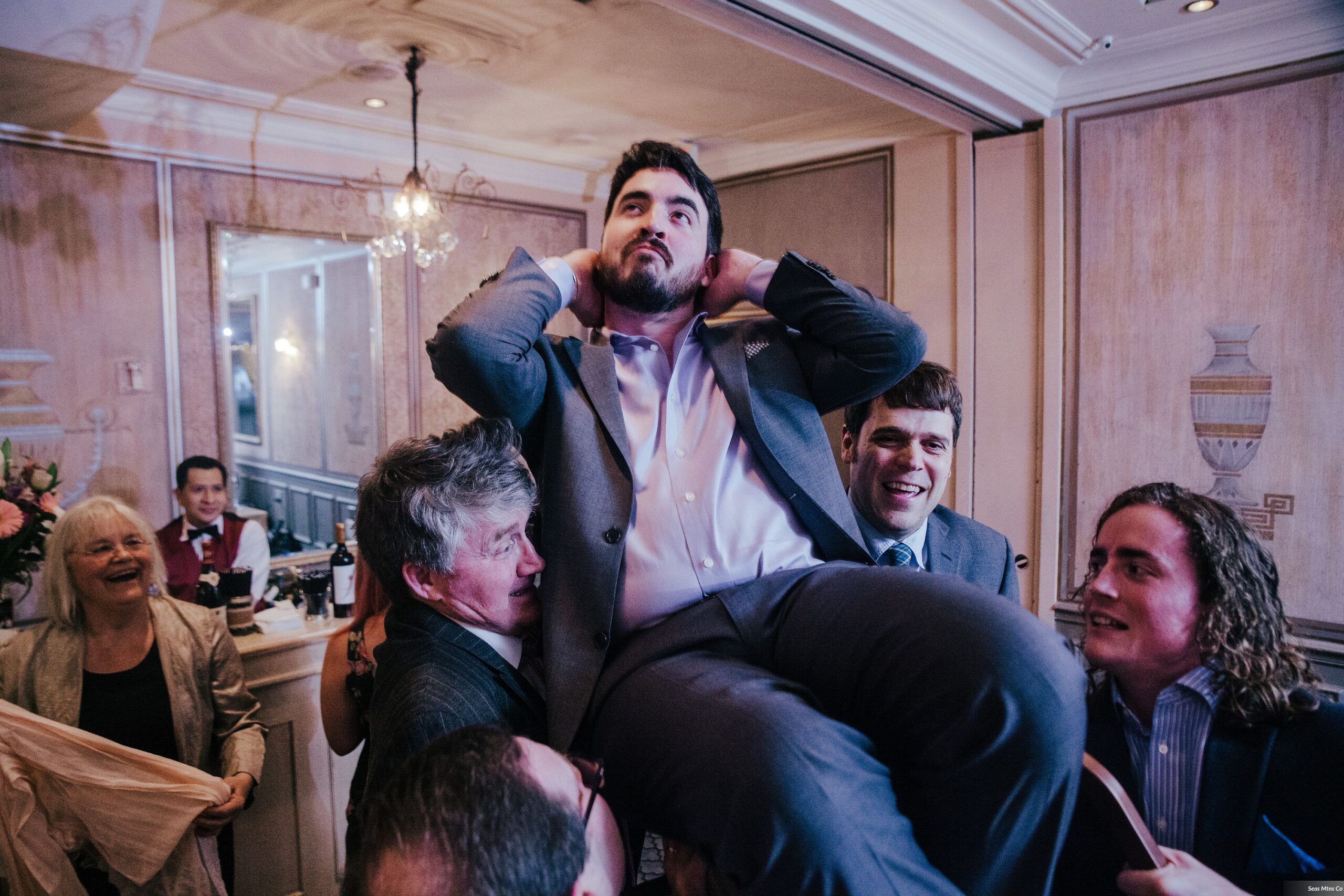 Groomsman held up on chair during hora at wedding at Lescale in Greenwich CT
