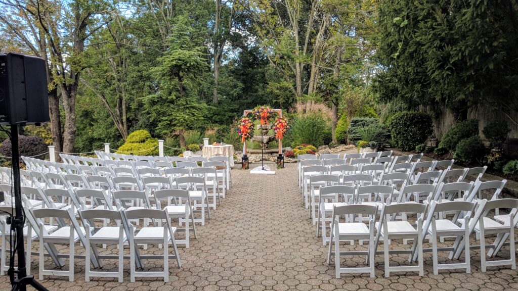 Ceremony seating with white chairs outside for a Fall Wedding at Mayfair Farms NJ