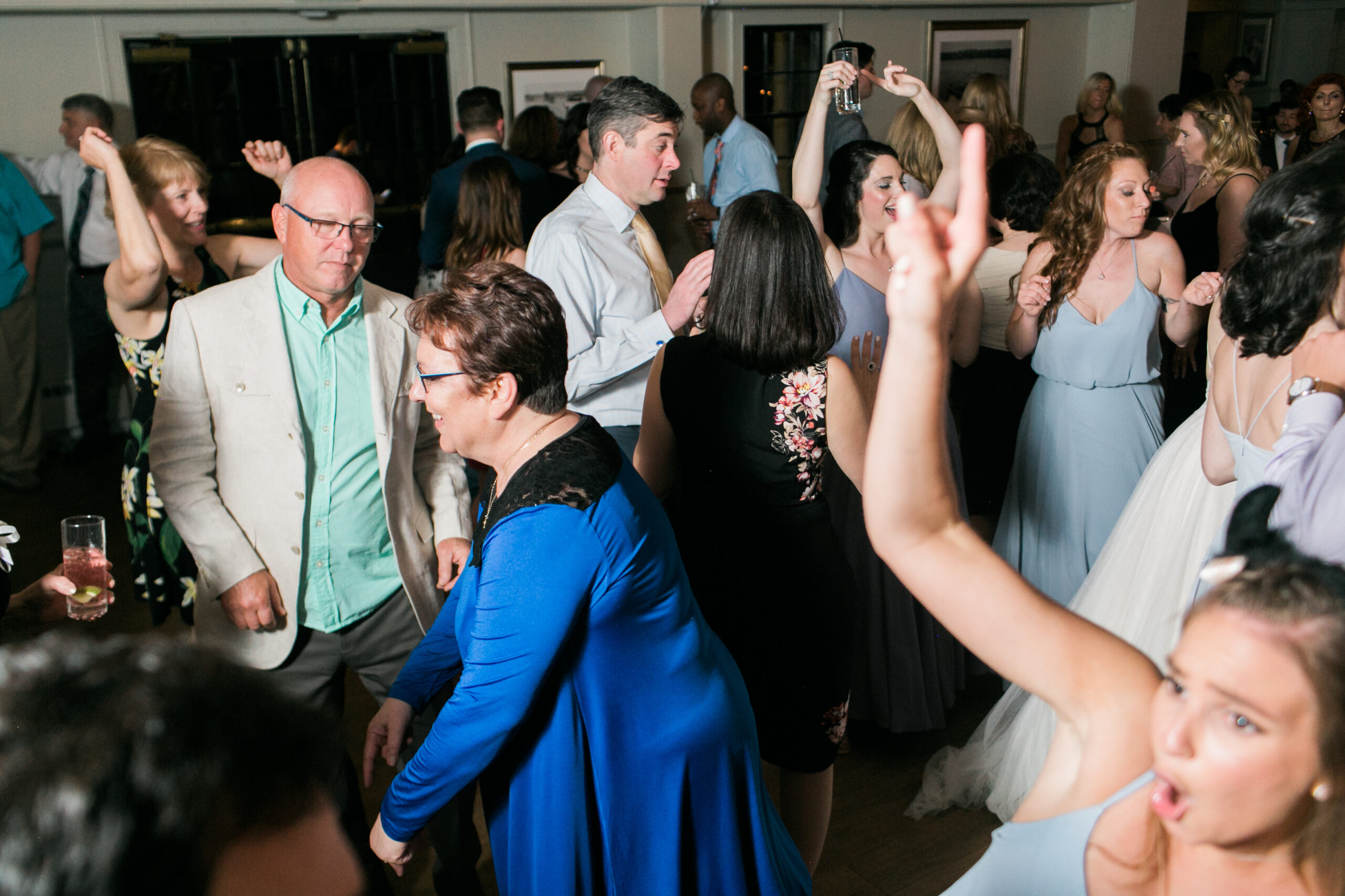 Older Wedding Guests dancing with bridesmaids on Dancefloor hands up at Latitude 41 Wedding Mystic