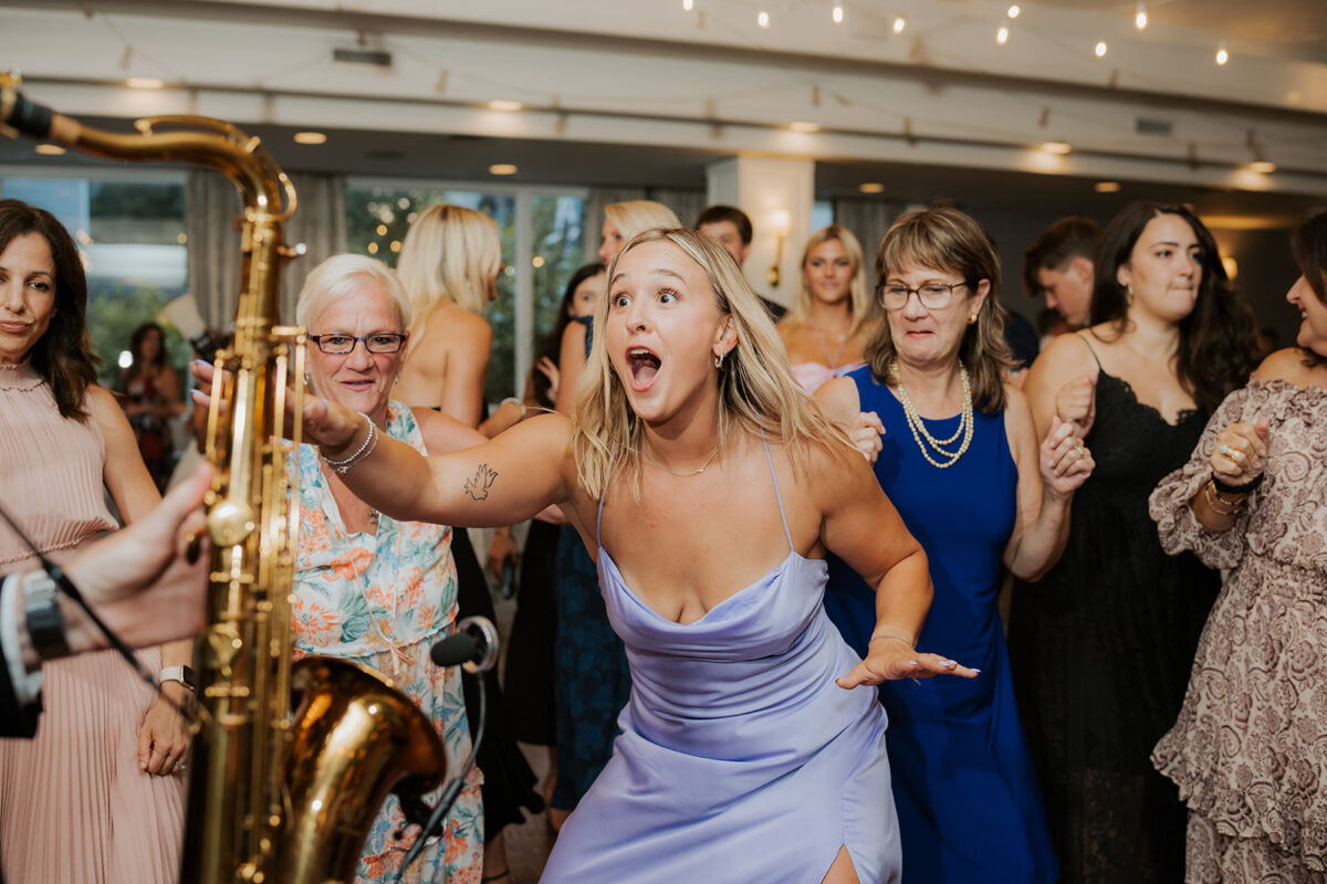 Waters Edge Wedding Venue, Westbrook CT wedding guests dancing with saxophone player