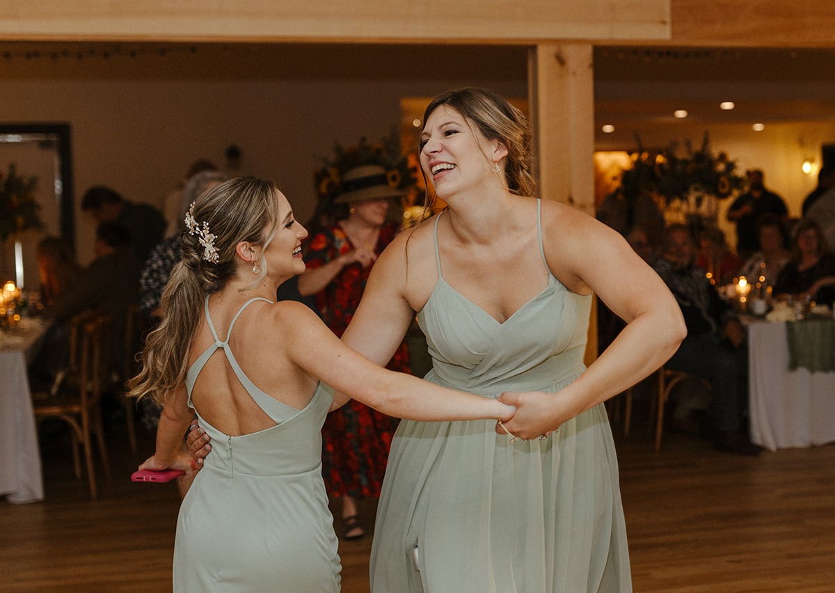 bridesmaids holding hands and dancing at a Magnanini Winery wedding