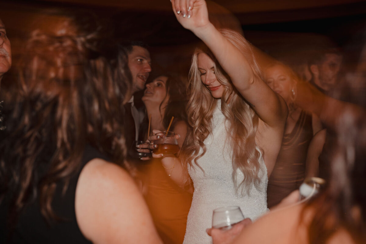 Bride dancing with hand in the air surrounded by friends and family at The Preserve at Chocorua in Tamworth NH