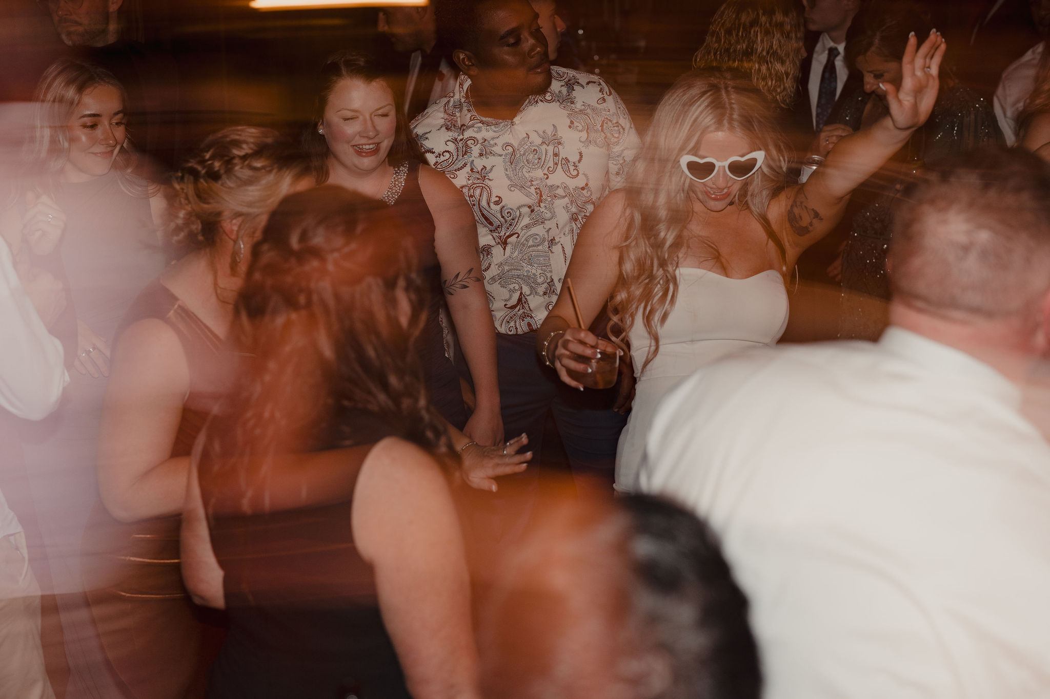 Bride smiling in heart shaped sunglasses on dancefloor at The Preserve at Chocorua in Tamworth NH