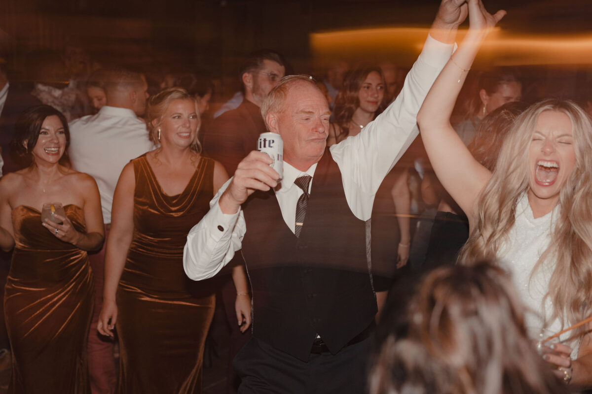 Ecstatic bride being twirled by her dad with a beer in hand at her wedding at The Preserve at Chocorua in Tamworth NH