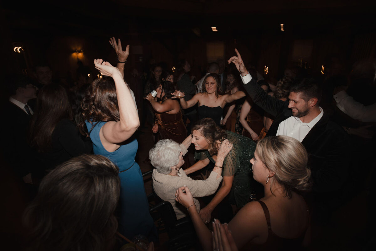 Smiling friends and family dancing with grandma at wedding at The Preserve at Chocorua in Tamworth NH