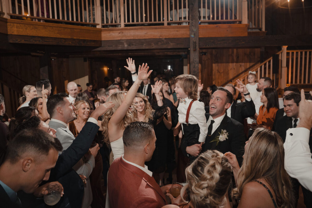 Bride and groom holding up kid on dancefloor at wedding at The Preserve at Chocorua in Tamworth NH